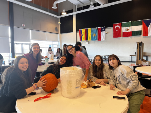 International students carving pumpkins